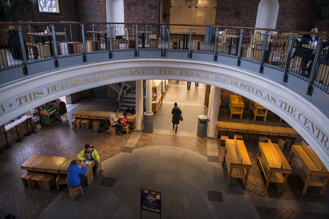 people gathered in a large multi level hall with tables